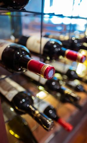 wine bottles on glass wine rack - indicative photo for the White Wine 750ml group