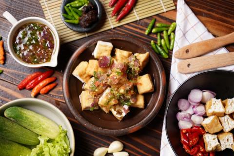 Fried tofu topped with chilli and herbs in a claypot